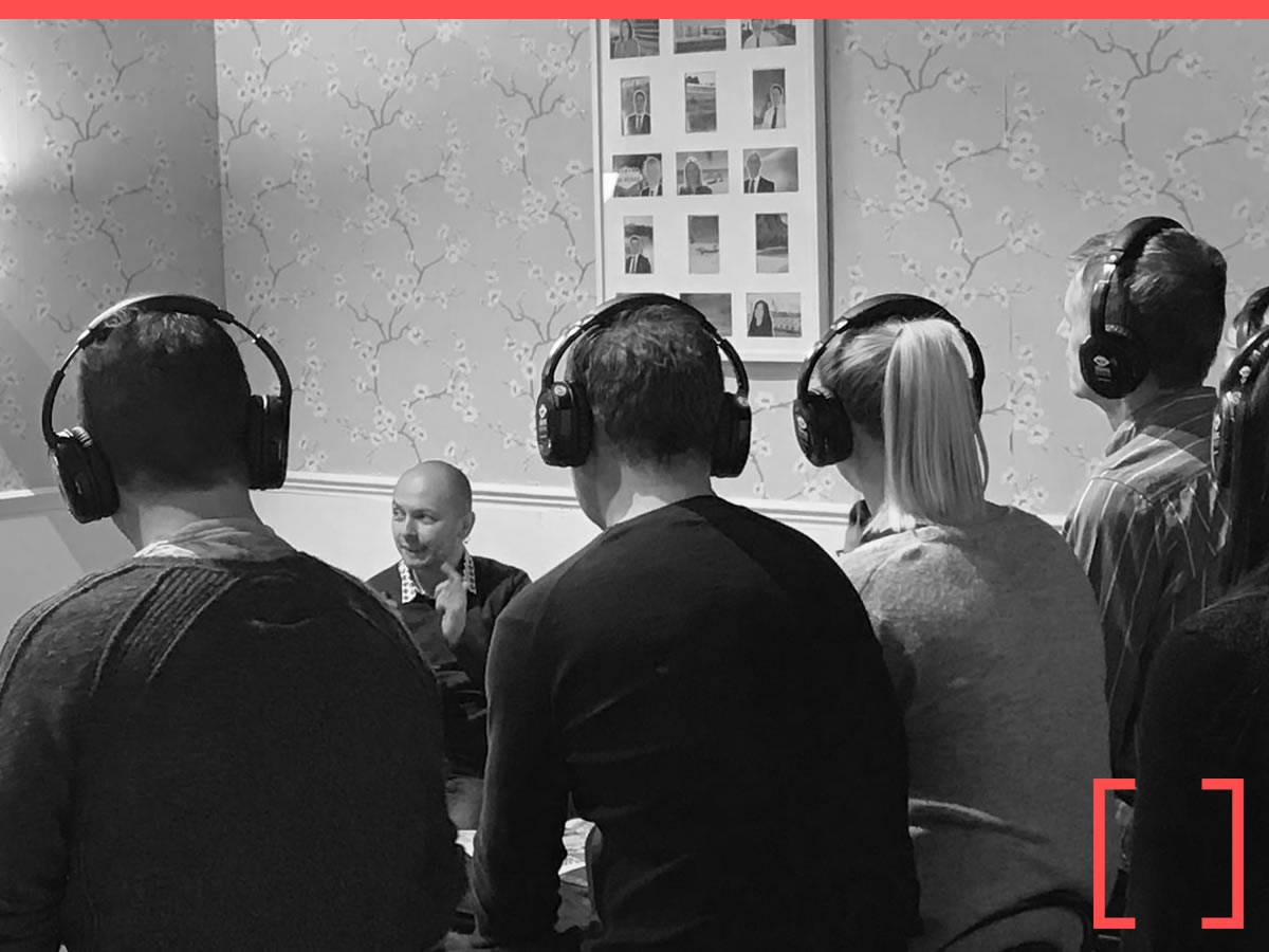 Exhibition stand visitors listening to a demo through wireless headsets