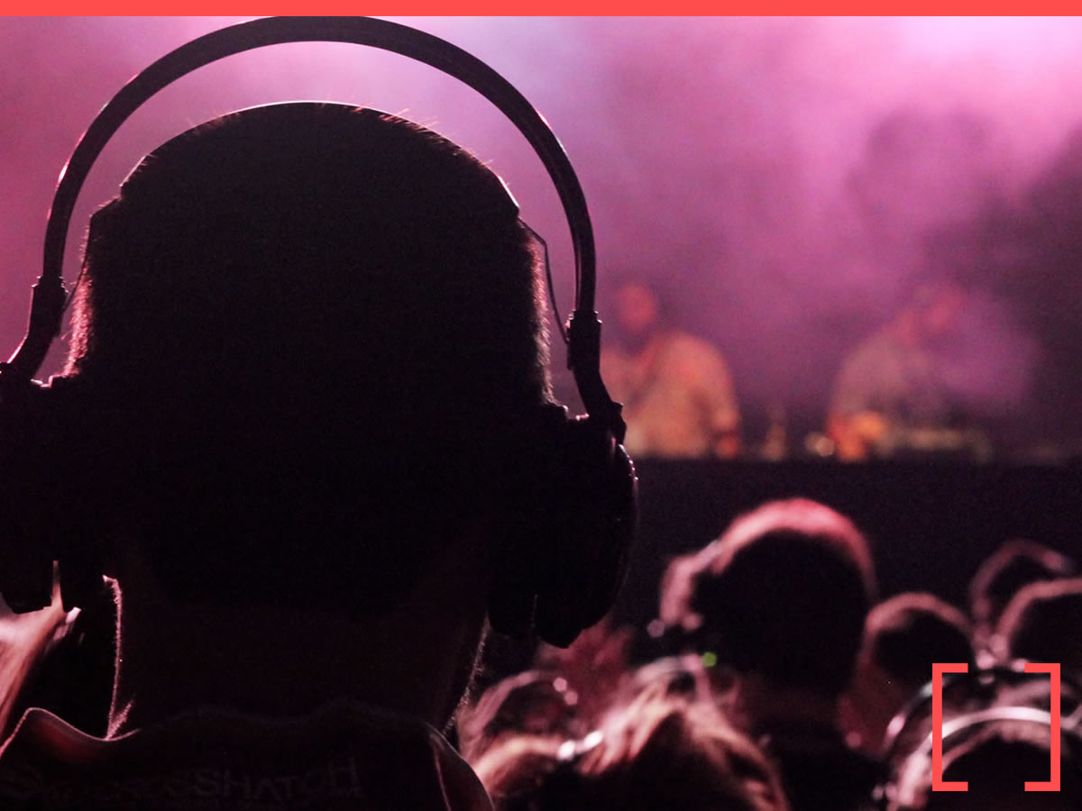 Festival goers wearing LED silent headsets outdoors
